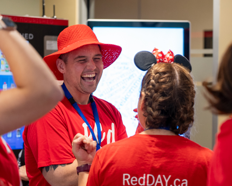 WRHN @ Queen's Blvd staff wearing their RedDAY merch and having fun.