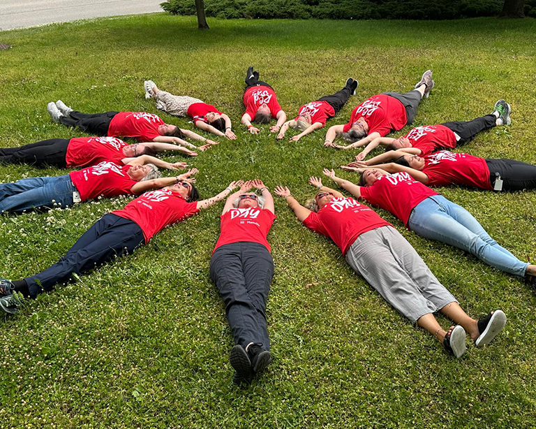 WRHN staff lying down in a circle on RedDAY, wearing their RedDAY t-shirts.