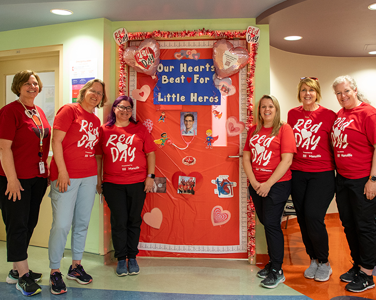 WRHN staff posing for a picture in front of their RedDAY decorations.